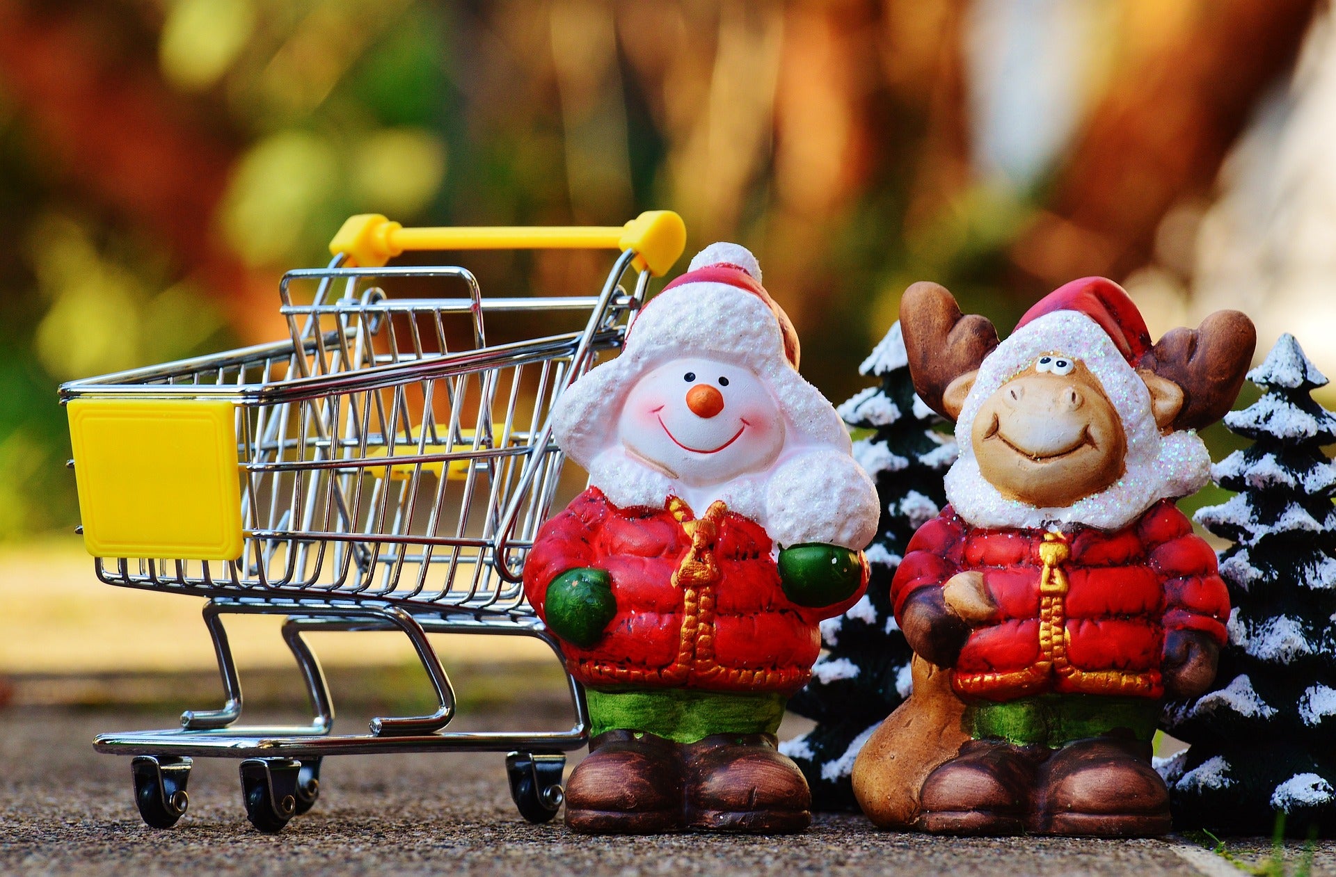 Festive Santa figures next to a shopping cart, perfect for holiday shopping to buy cheap mechanical keyboards for Christmas gifts.