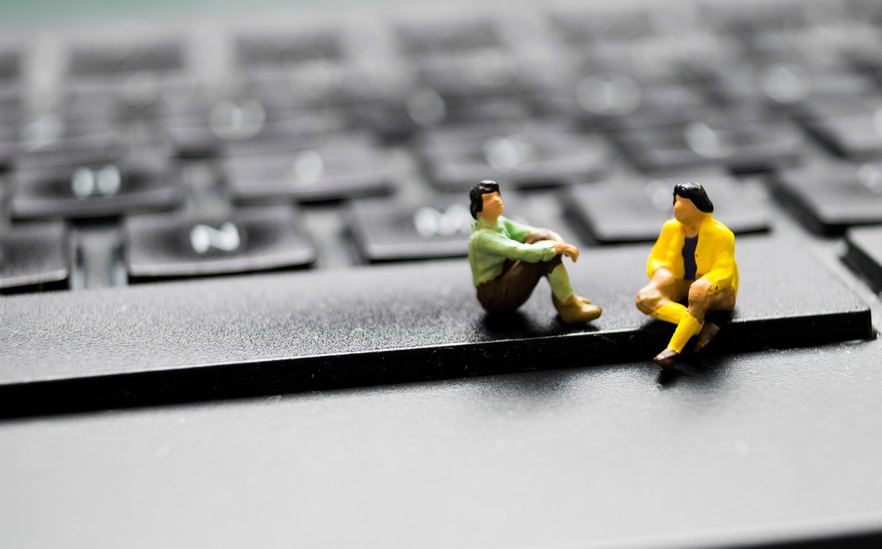 Miniature figures sitting on a mechanical keyboard illustrating mechanical keyboard benefits